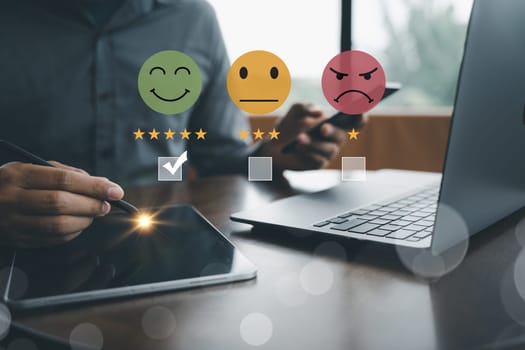 Customer satisfaction and service quality survey being conducted by businessman using a virtual screen to measure feedback through smiley face icon with the highest level. Result is a positive review