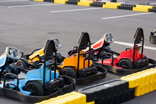 Colorful recreational Go-kart race excitement. Go kart machines lined up on the track, ready for high-speed motorsport action and thrilling competition.