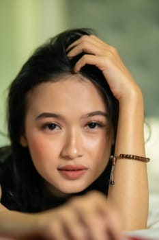 Unfocused and blurry faces of Asian women wearing a black dress in the bed