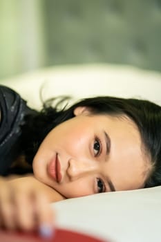 Indonesian women sleeping alone in her bad and she have a black hair while wearing a black dresses