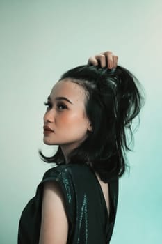 Rear look of Asian women wearing a black dress while she holding her hair and feeling sexy wearing it