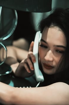 A Woman holding a phone and put it in her ear while calling the police for a crime