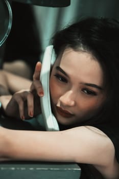 A Woman holding a phone and put it in her ear while calling the police for a crime