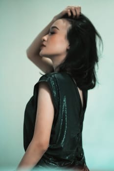 Rear look of Asian women wearing a black dress while she holding her hair and feeling sexy wearing it