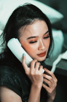 Beautiful women receive phone calls from a loved one in the night while she wearing a black dress and have a black hair