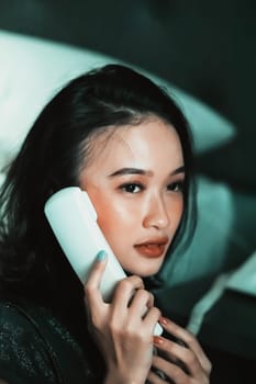Beautiful women receive phone calls from a loved one in the night while she wearing a black dress and have a black hair