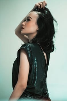 Rear look of Asian women wearing a black dress while she holding her hair and feeling sexy wearing it