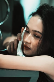 A Woman holding a phone and put it in her ear while calling the police for a crime