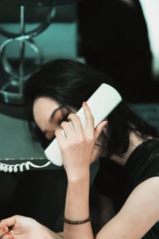 Asian women make a phone call while wearing a black dress and bracelet in her hand, she holds the phone and put it in the ear