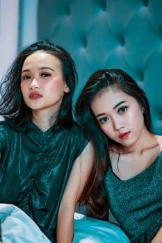 Two young Asian Women in Bed together with best friend