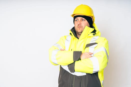 a man wearing a yellow working winter jacket and a yellow safety helmet . High quality photo