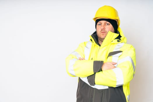 a man wearing a yellow working winter jacket and a yellow safety helmet . High quality photo