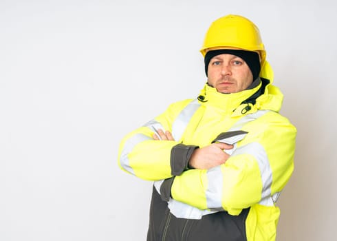 a man wearing a yellow working winter jacket and a yellow safety helmet . High quality photo
