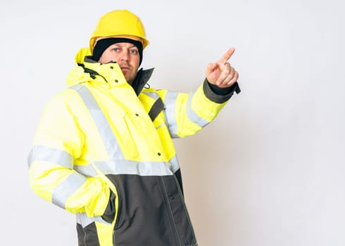 a man wearing a yellow working winter jacket and a yellow safety helmet . High quality photo