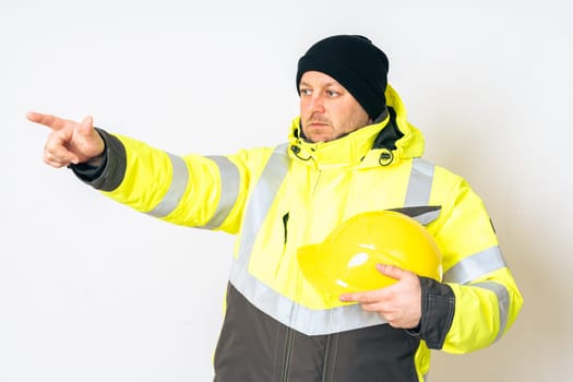 a man wearing a yellow working winter jacket and a yellow safety helmet . High quality photo