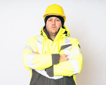 a man wearing a yellow working winter jacket and a yellow safety helmet . High quality photo