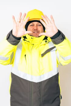 a man wearing a yellow working winter jacket and a yellow safety helmet . High quality photo