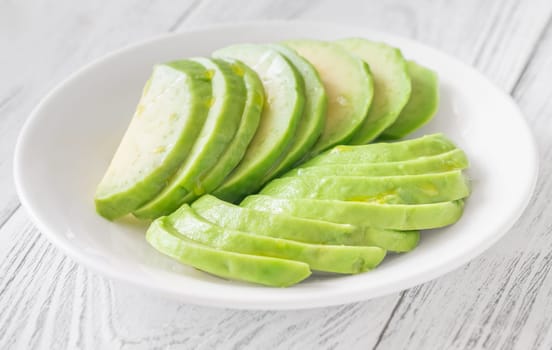 Creamy avocado slices arranged neatly in bowl, ready for topping or dip