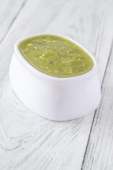 Bright green salsa verde swirled into bowl, tangy flavor with smooth texture