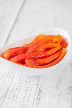 Charred red pepper strips arranged in bowl, smoky and sweet flavor showcased