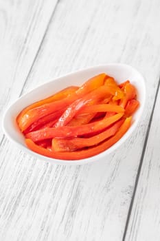Charred red pepper strips arranged in bowl, smoky and sweet flavor showcased