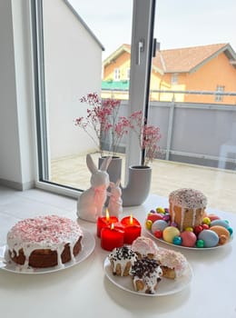 Festive dessert display showcases colorful cakes, decorative candles, and Easter-themed decorations, creating a joyful atmosphere ideal for celebration and gathering during spring festivities