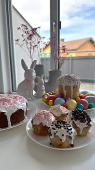 Baked goods and painted eggs for Easter arranged on a table with vibrant decorations and flowers, creating a joyful ambiance for celebrations and gatherings, ideal for spring festivities and special occasions