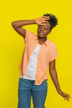 African American woman holds head swaying unsteadily with a disoriented expression and visible struggle. Black girl isolated on yellow background highlights dizziness, imbalance, and physical weakness
