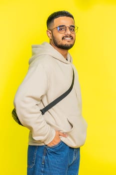 Cheerful lovely happy young Indian man smiling friendly glad expression looking at camera dreaming resting relaxation feel satisfied good news. Arabian guy isolated on yellow background. Vertical