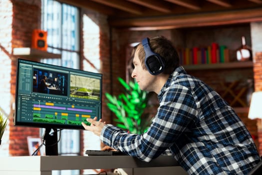 Video editor selecting key frames to use while doing video montage, working from home on computer before deadline. Man using mouse to edit movie project footage in apartment office