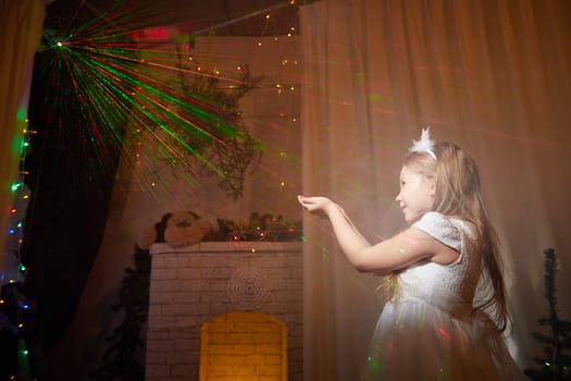 A child happily interacts with colorful lights in a beautifully decorated room for Christmas and New Year celebrations.
