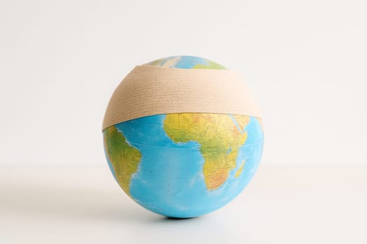 AI generated realistic globe with bandage wrapped around it symbolizing environmental damage and healing concept white background climate change earth protection conservation metaphor