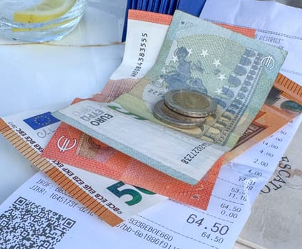 Tivat, Montenegro - April 25, 2025: a check with money on the table at Il Pescatore cafe,Marina Porto Montenegro