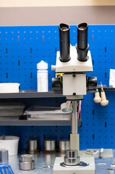 workshop for metal coin press form preparation with blanks and microscope