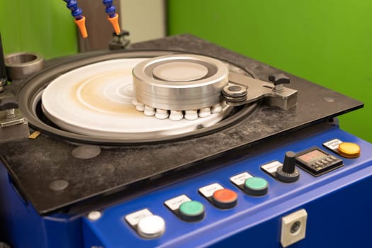 polishing machine for coins at work with watering the part of a special cooling liquid