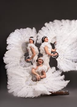 Top view of bride and groom in elegant bride in white wedding dress standing on black background and looking at camera