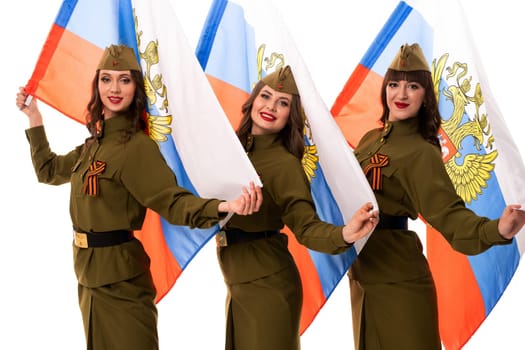 Delighted female models in military clothes with St George ribbons holding Russian flags and looking at camera against white background