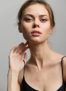 Portrait of a confident woman with minimalistic style, conveying elegance and sophistication in a simple setting. Focus on natural beauty and poise.