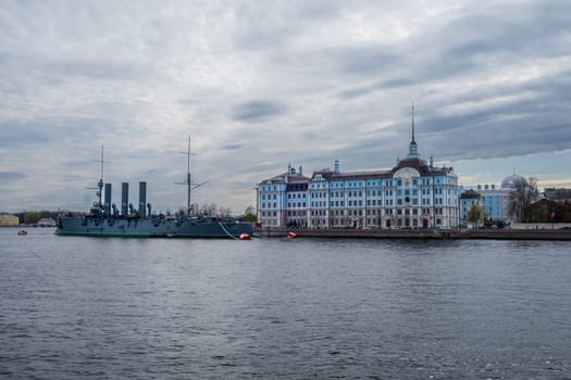 Saint Petersburg, Russia - 02.05.25. Cruiser Aurora moored near Nakhimov Naval school on the Neva River in St. Petersburg. Iconic landmarks represent Russia's maritime heritage and educational legacy.