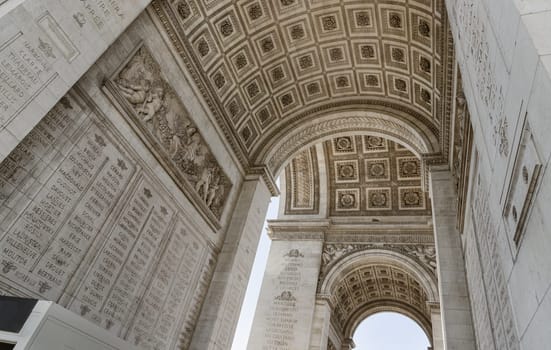 France, Paris - May 03, 2025 - Stunning details view of ornate stone carvings under the arch of the famous Arc de Triomphe. Iconic touristic architectural landmark of Paris, use it as your Wallpaper, Poster and Space for text, Selective focus.