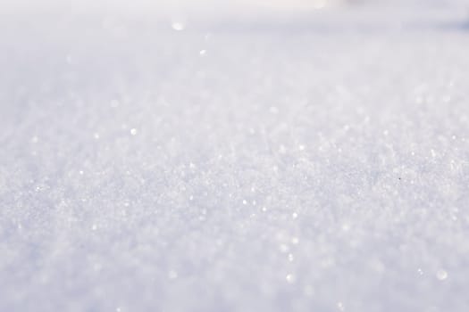 Macro of glittering white snow crystals under soft daylight, capturing the peaceful and pure texture of fresh winter snow in a minimalist natural frame.