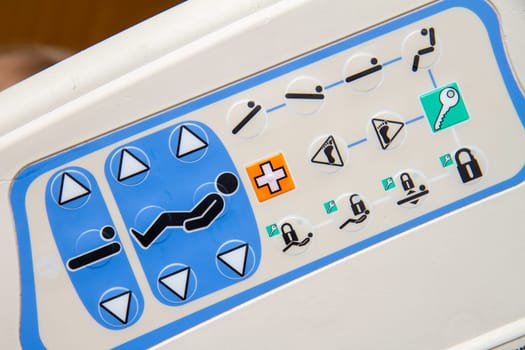 A white and blue device with a lot of buttons from a hospital bed