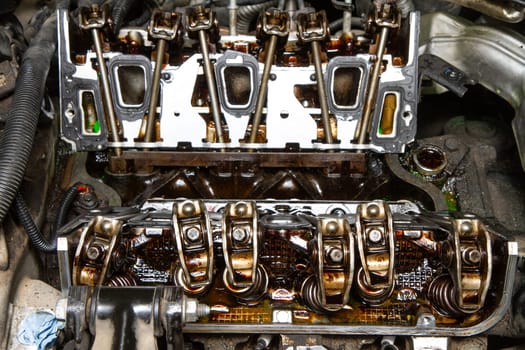 The engine of a car is open and the valves are visible. The valves are rusty and the engine is in need of repair