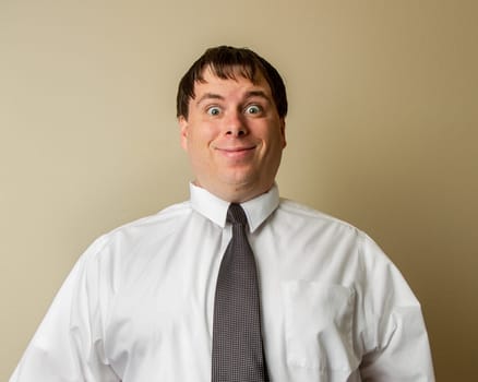 A man wearing a white shirt and a black tie is smiling and looking at the camera. Concept of professionalism and confidence, as the man is dressed in a business attire