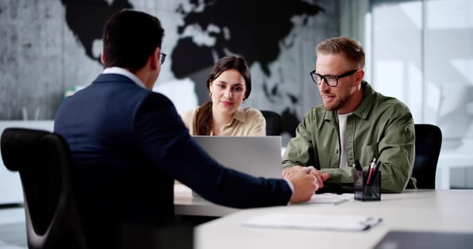 Young Couple Consults With Travel Agent For Dream Vacation Package.