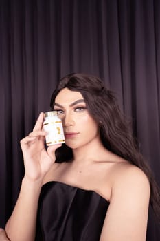 Beautiful Asian woman holding a white jar in a black dress and a black curtain in the background
