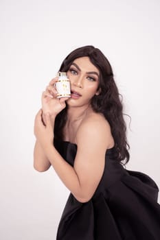 Asian woman poses with skincare in her hands while wearing a black wedding dress inside the studio