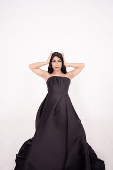 A whole body of an Asian woman in a black dress poses in a white studio with dark brown hair