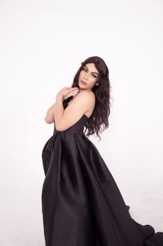 Asian woman in a black bride dress with a tail pose in a white room inside the studio
