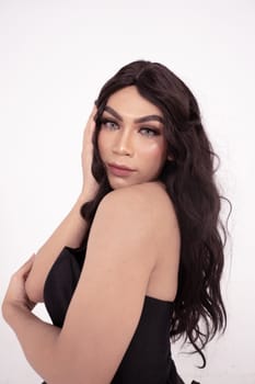 Asian woman sadly holding her face with her hand while wearing a black dress with brown hair